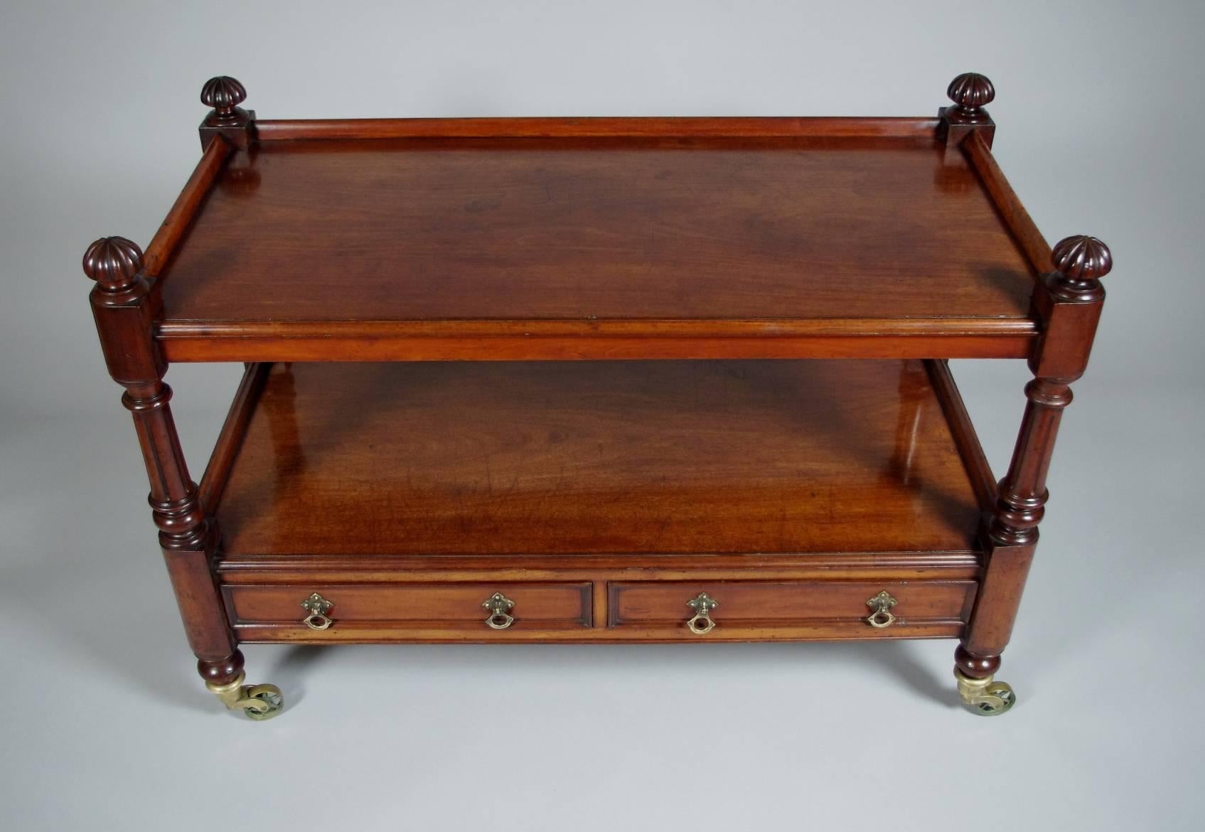 Victorian mahogany serving trolley, the two galleried shelves raised on fluted posts with large mushroom finials, the two drawers with dividers and original hardware, all on replaced brass casters.