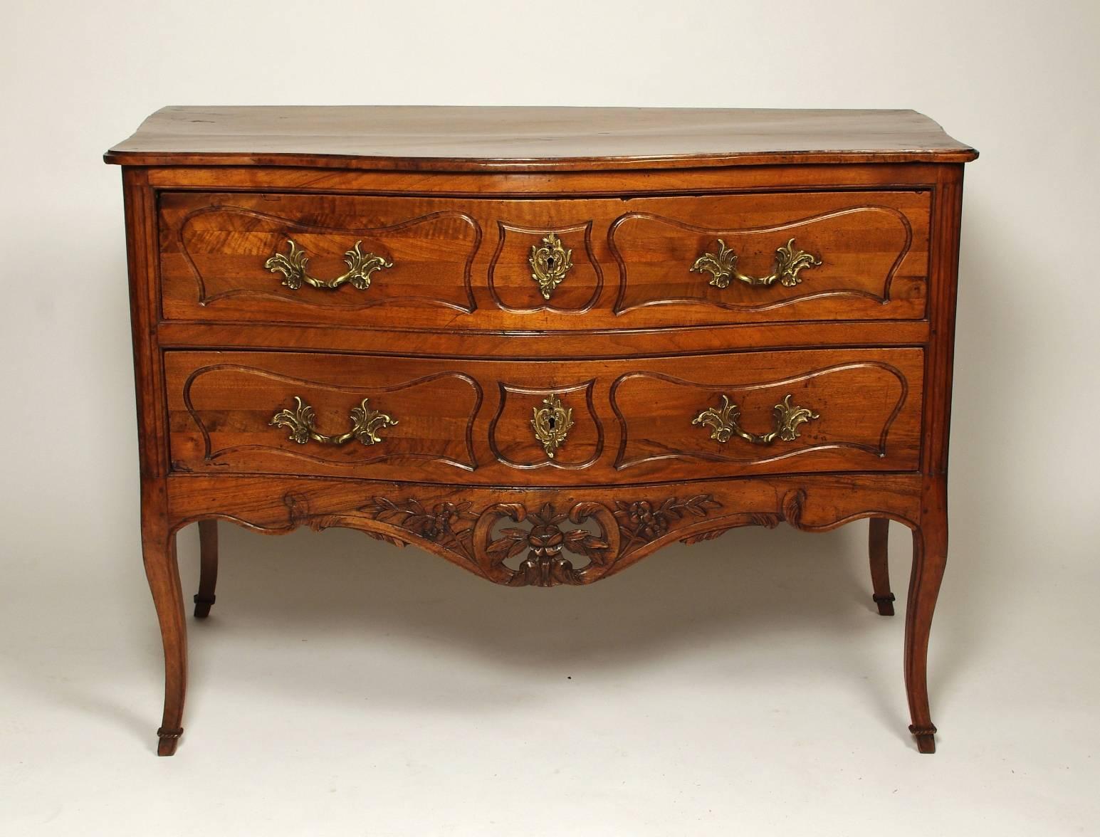 Louis XV walnut serpentine chest of two drawers (commode sauteuse), the two-board top with molded edge edge over two long drawers, each with replaced hardware and escutcheons within incised cartouches and built from molded and laminated strips; the