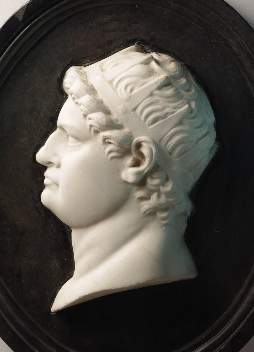 Grand Tour marble plaque of Nero in profile wearing a crown, carved in white marble and set within a black marble oval plaque.

The corpulent figure depicted in this plaque is almost certainly Nero. Infamous for his debaucheries and political