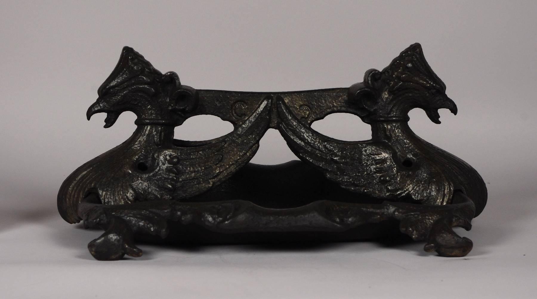 Fine cast iron boot scrape in two parts, the blade supported by a pair of adorsed griffins, the shaped tray with acanthus leaves to the corners, on scroll feet. Registry mark for 1851.
