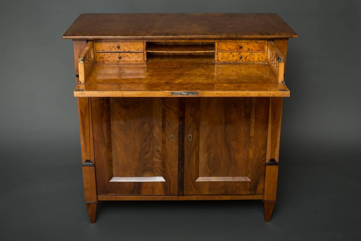 Biedermeier Walnut Secretary Chest, Biedermeier walnut secretary with cabinet below.  Desk has four small drawers and a letter shelf.  Cabinet comes with one interior shelf.  Lovely grain detail and contrasting colored accents.
