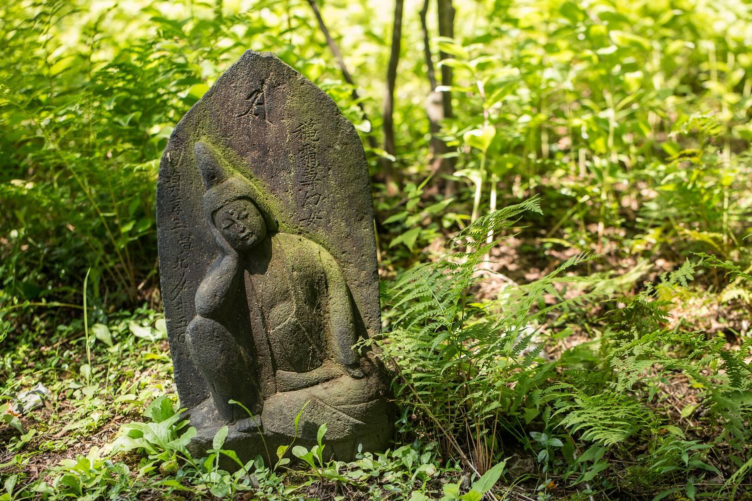 Early carved granite sculpture of a sleeping Buddha, with calligraphy.

Measures: 25