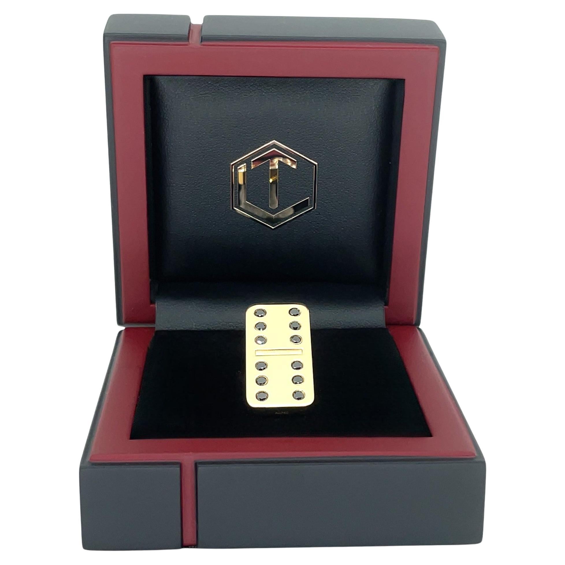 Der imposante Dominostein ist aus 18 Karat Gold gefertigt, vollmassiv und mit 12 schwarzen Diamanten im Brillantschliff besetzt.
Mit einem Gesamtgewicht von 25 Gramm, einer Länge von 29 mm, einer Breite von 14 mm und einer Tiefe von 4 mm, ist der