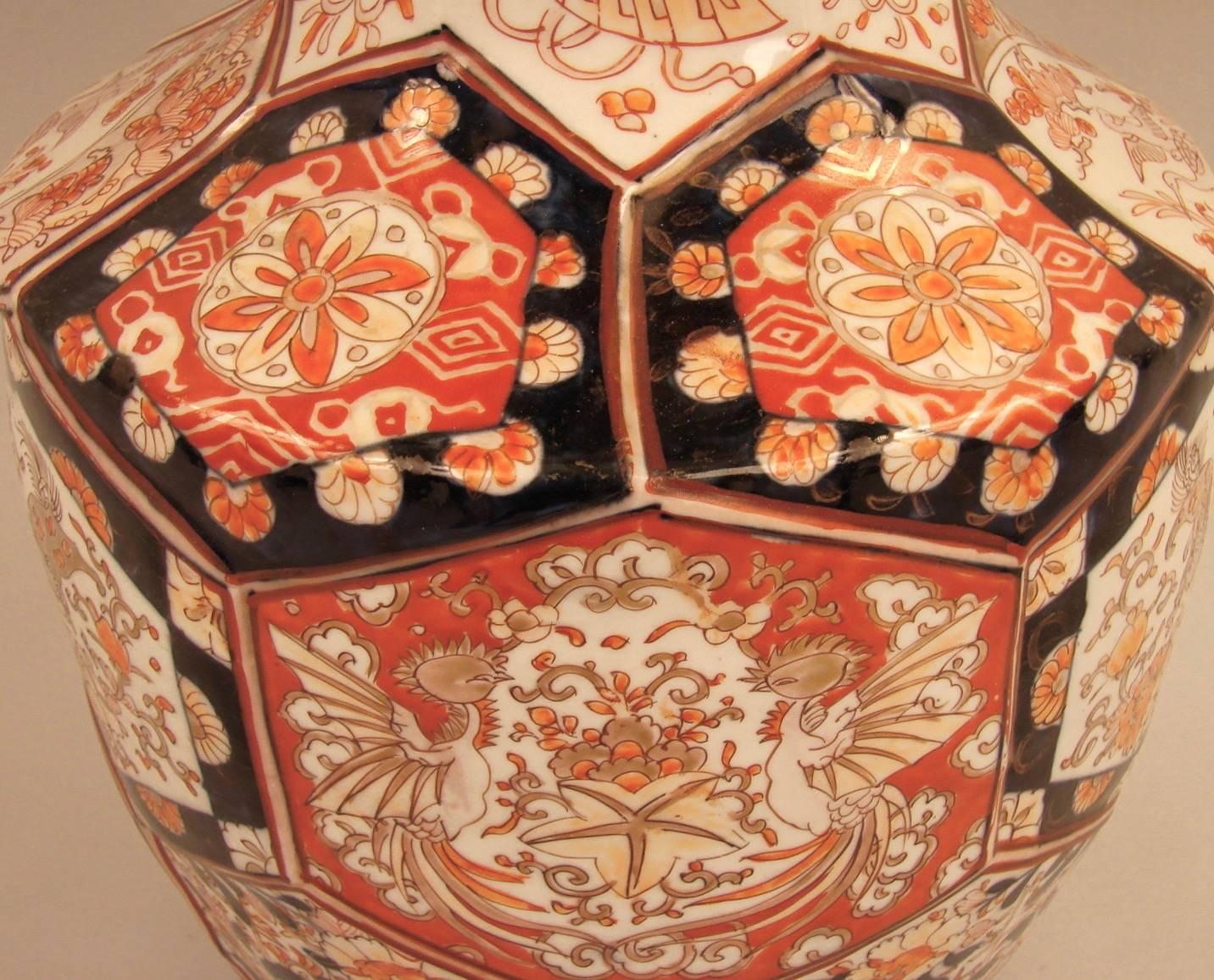 A large Imari Meiji period vase of faceted baluster form with a flaring lip, decorated in typical oranges and dark blues.