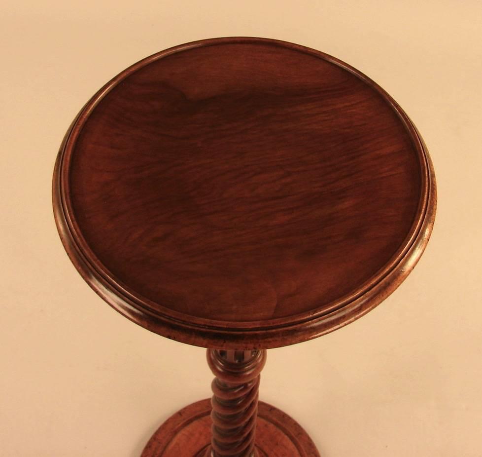 An English William and Mary style candle stand, the dished circular top supported by a reeded and rope turned standard ending in a turned weighted base, 19th century.