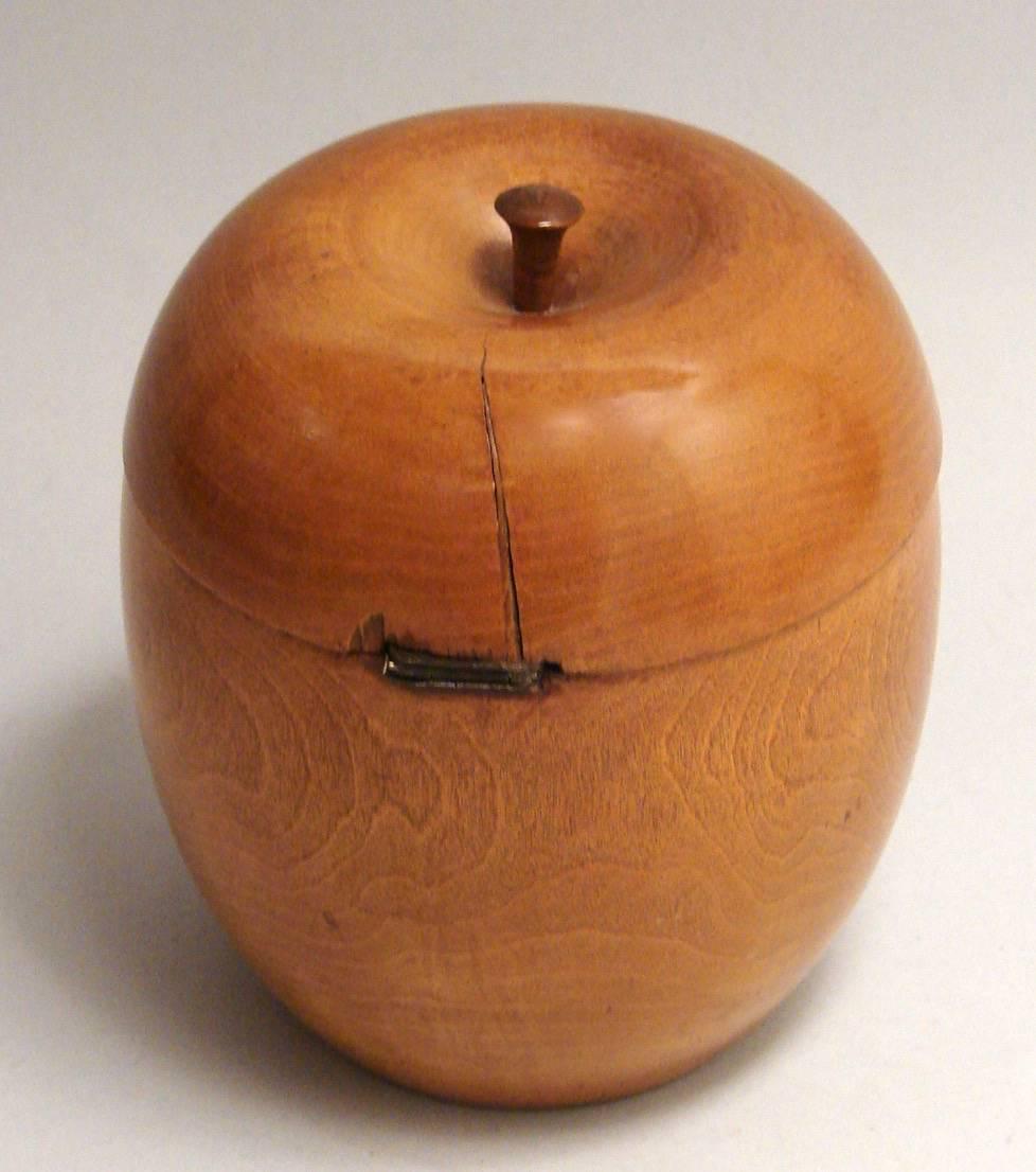 An English pear wood tea caddy in the shape of an apple, the interior with remnants of a foil lining. Circa 1780-1800.