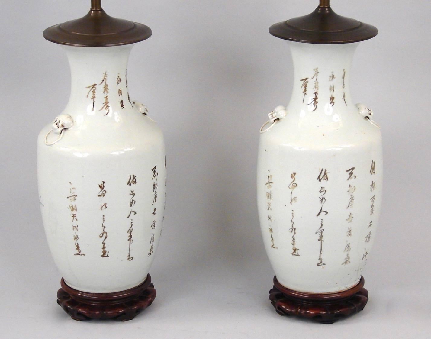 A pretty pair of Chinese porcelain vases, now electrified, decorated overall with figures in a garden setting in tones of brown, pale blue and rose, the backs with Chinese characters, late 19th century.