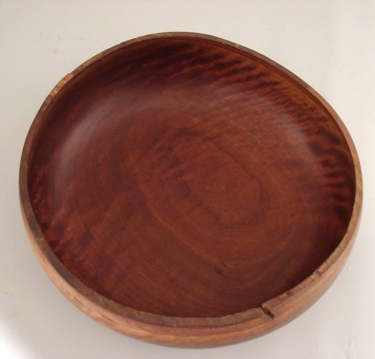 A lovely turned red gum eucalyptus bowl of large size with a live edge, made and signed by John T. Doyen, a former University of California professor of entomology.