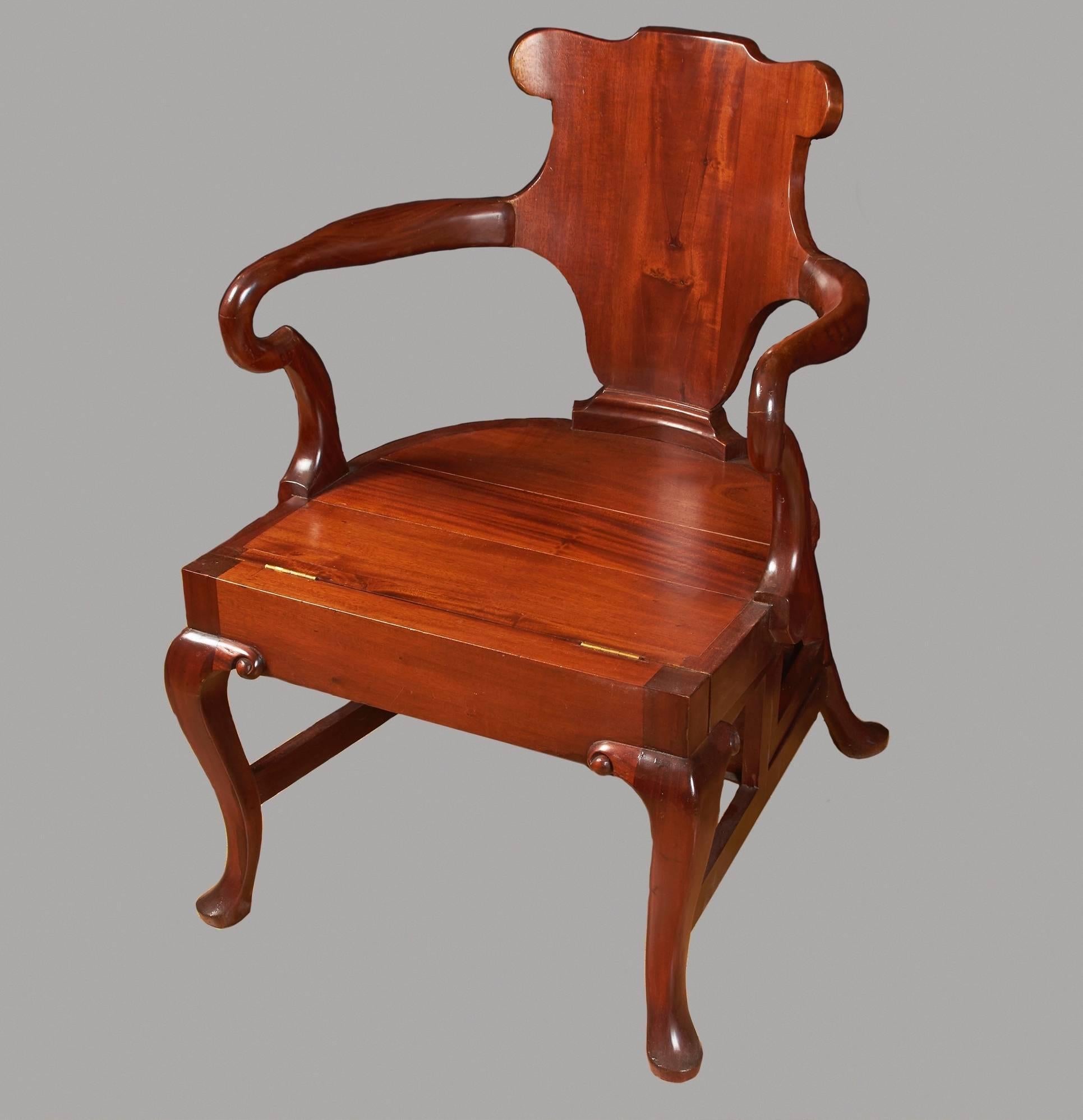 A large English mahogany metamorphic armchair in the George II taste, the shaped back with shepherd's crook arms, the plank seat opening to reveal four inset steps, all on cabriole legs ending in pad feet. 20th century.