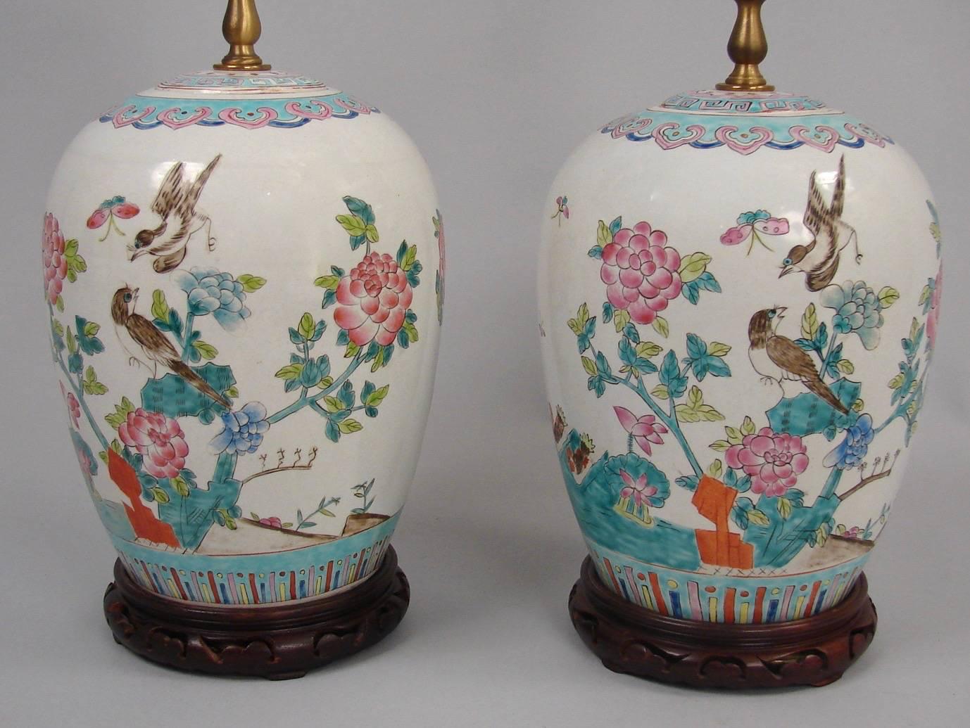 A pair of Chinese vases decorated with Phoenix birds in a naturalistic setting in tones of blue and rose, 20th century. New shades included.