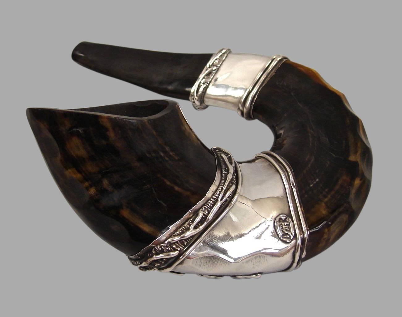 A polished ram's Horn shofar mounted with silver bands decorated with Hebrew letters and inset with hard stone. 20th century.