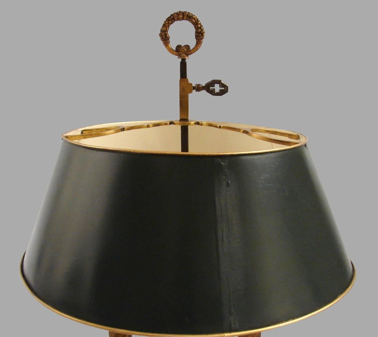 A good quality French Louis XVI style gilt-brass two-light bouillotte lamp with adjustable shade and candle arms, nicely detailed with faces retaining its original meta shade, circa 1900. Now electrified.