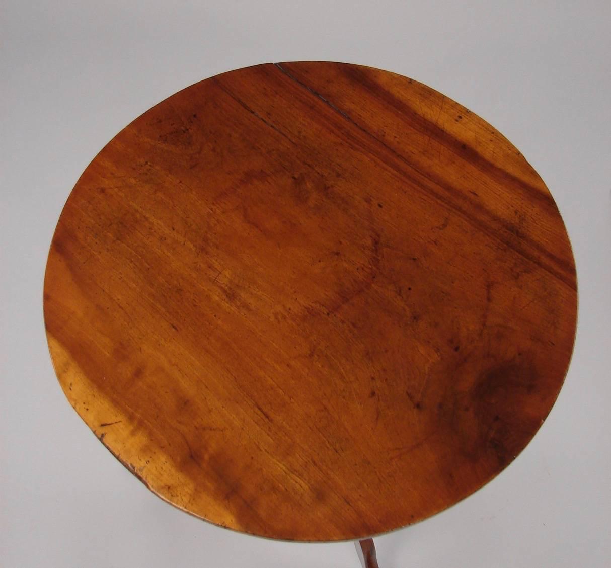 An English Provincial George III period solid yew wood wine table, the circular figured top supported on a turned standard ending in a tripod base with pad feet, circa 1800.