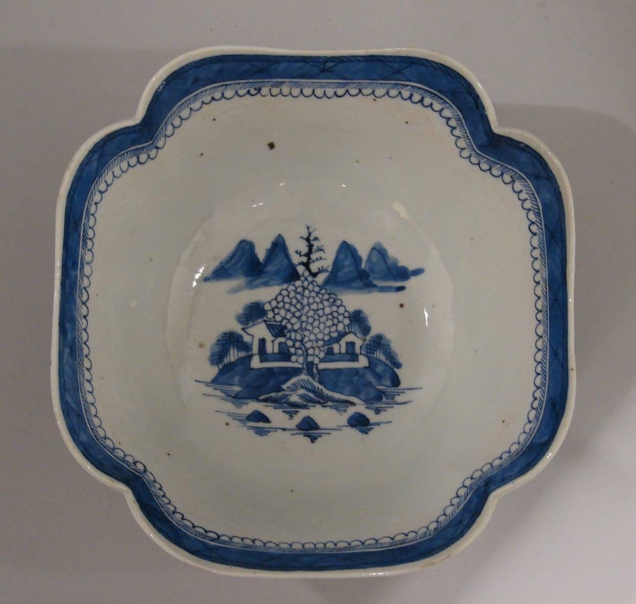 A Chinese export canton blue and white bowl of petal form decorated overall in typical fashion with buildings in a lake setting, circa 1850.