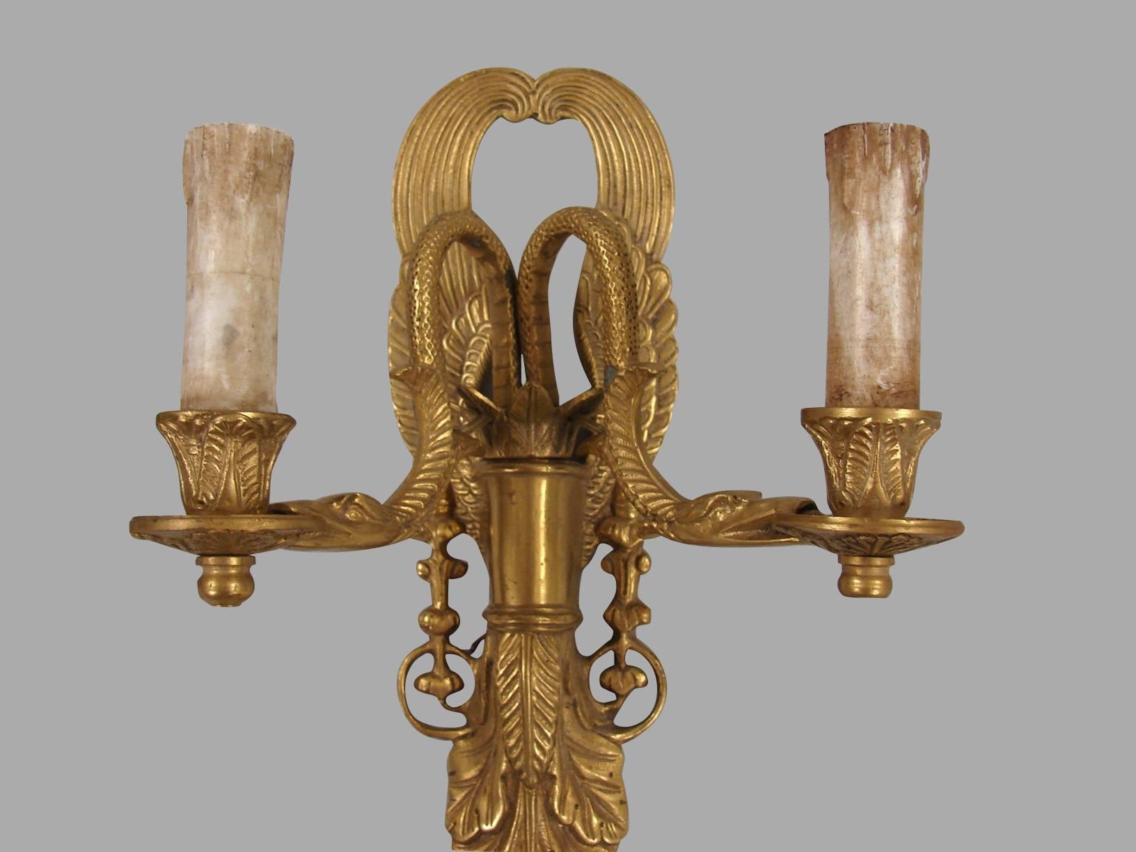 A set of four Empire style brass or bronze sconces the backplates with a feather design, the candle arms of serpent form, 20th century.