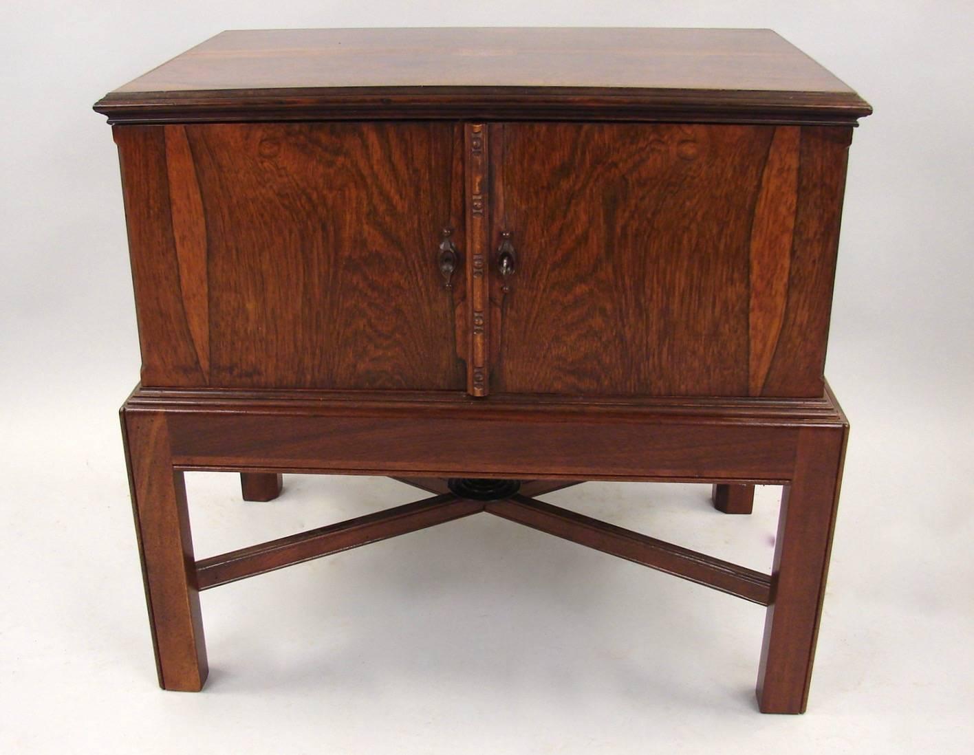 A fine quality English figured rosewood small chest, the top with inlaid stylized silver monogram above two cabinet doors opening to reveal three green stained maple drawers, lined in satin, now on a custom stand of a later date, circa 1870.