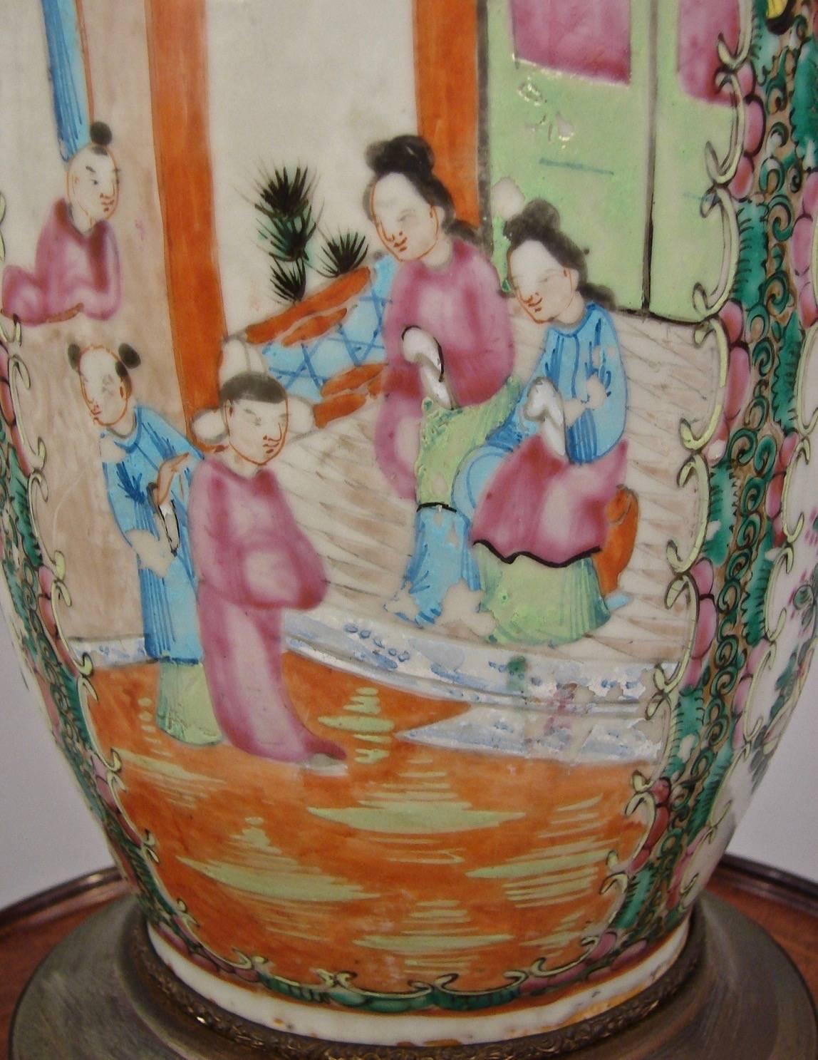 A pretty Chinese export rose medallion vase decorated overall with figures, flowers and birds in blue, rose and tangerine on a cream background, with gilt handles. Now electrified and mounted on an engraved brass base of a later date. Vase circa