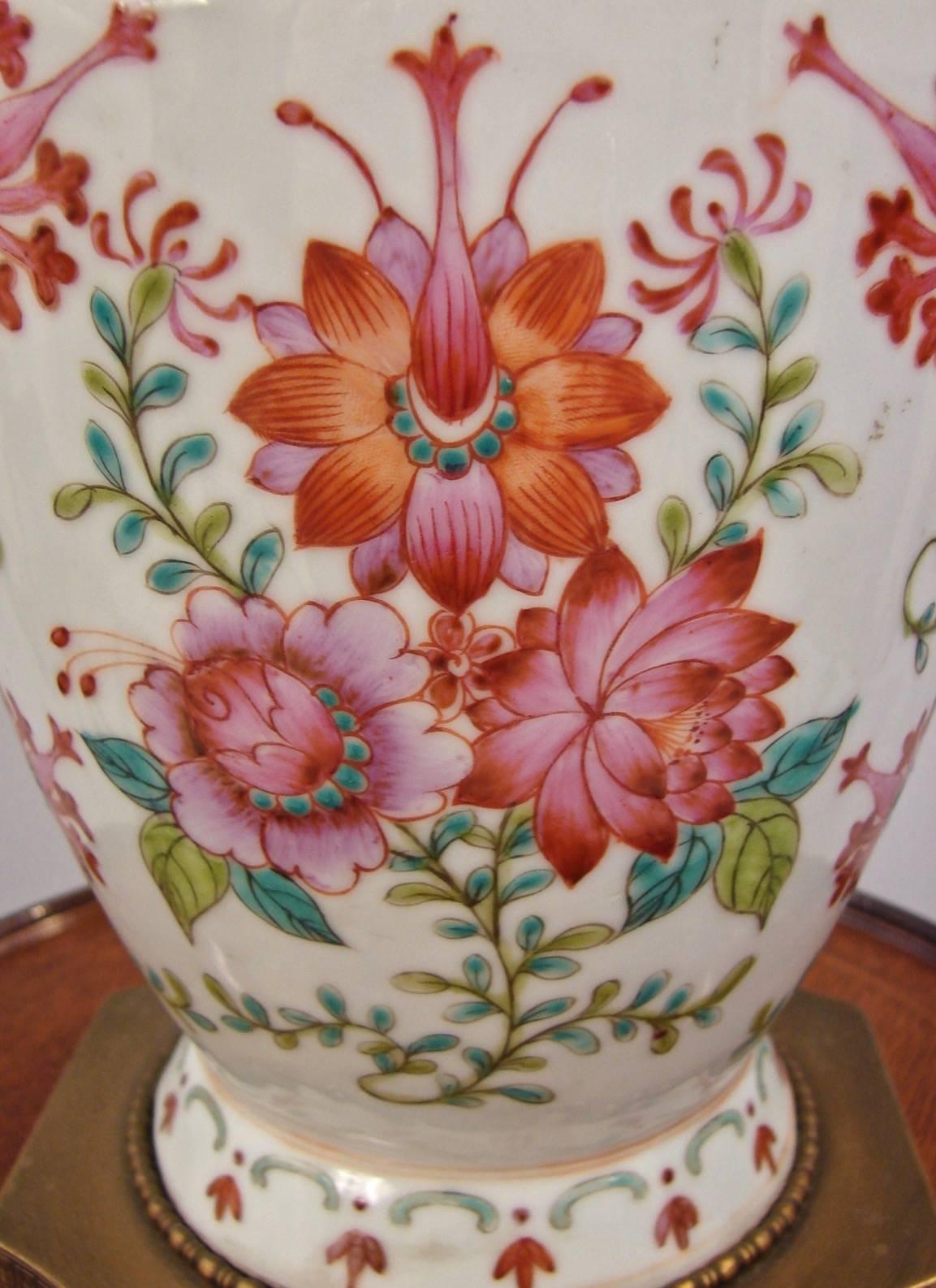 A pretty Chinese export vase decorated overall with peonies in tones of rose with pale orange serpent form handles. Now mounted on a brass base, circa 1900-1920.