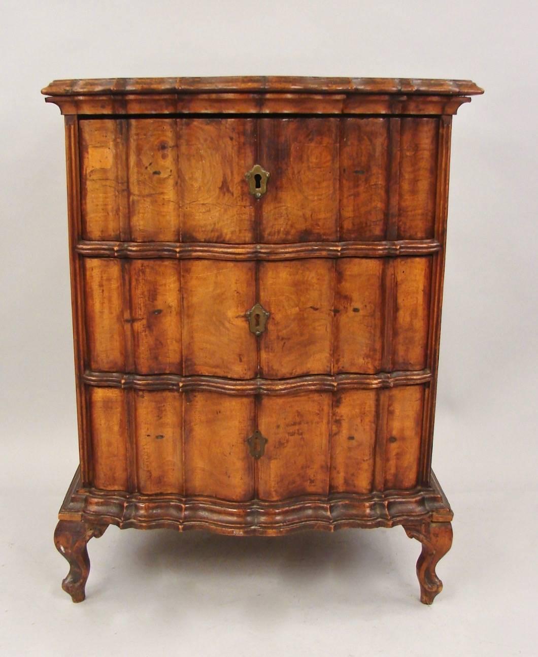 An Italian walnut neoclassical commodino with a single drawer and a side cabinet door, the top and front of shaped wavy form, supported on short cabriole legs. Attractive old color and patina, circa 1790-1800.