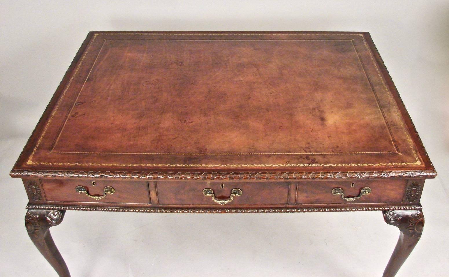 A substantial Georgian style partner's writing table, the brown gilt-tooled inset leather top with a gadrooned edge above three cockbeaded drawers the reverse identically configured with carved rosettes at the corners supported on later cabriole