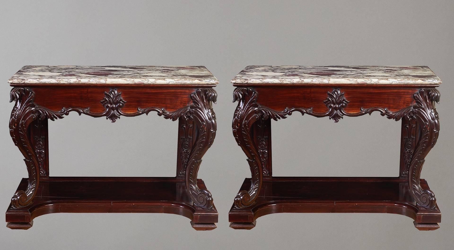 A rare pair of Chinese export hardwood console tables, each with a rectangular marble top above a carved frieze on cabriole supports raised on a platform. (For a similar single table, see Sotheby's 