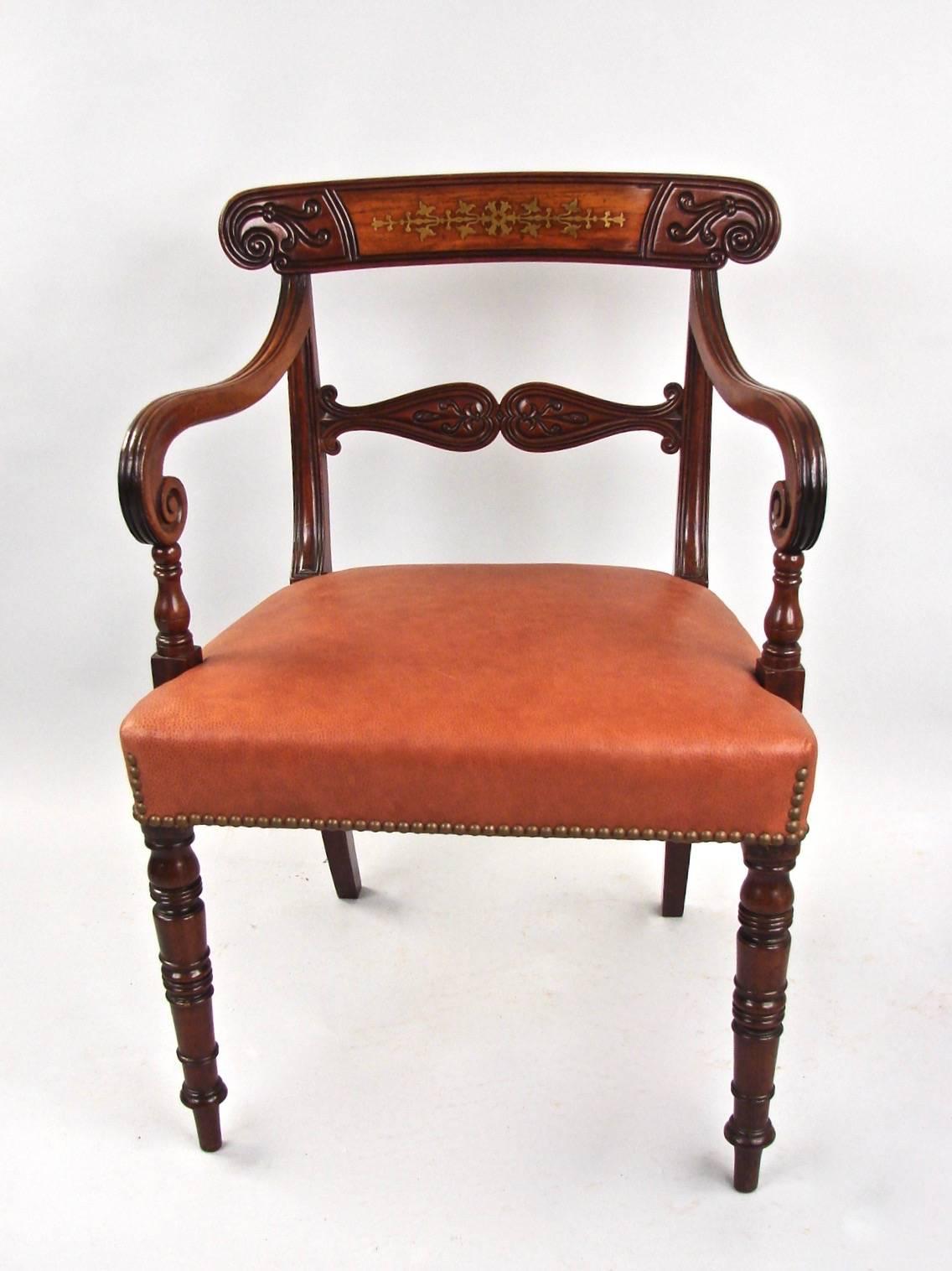 A fine set of eight Regency brass inlaid mahogany dining chairs consisting of two-arm and six side chairs, each with brass inlaid back splats with carved ears, over carved splats, the newly upholstered leather seats with nailhead trim supported on
