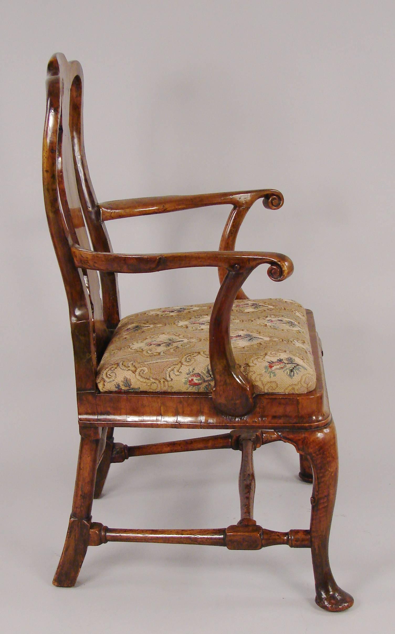 A fine George I walnut veneered open armchair, the inlaid vasiform splat terminating in a shaped seat supported on cabriole legs ending in pad feet joined by a shaped stretcher, circa 1720. Provenance: Florian Papp, N.Y.C.
