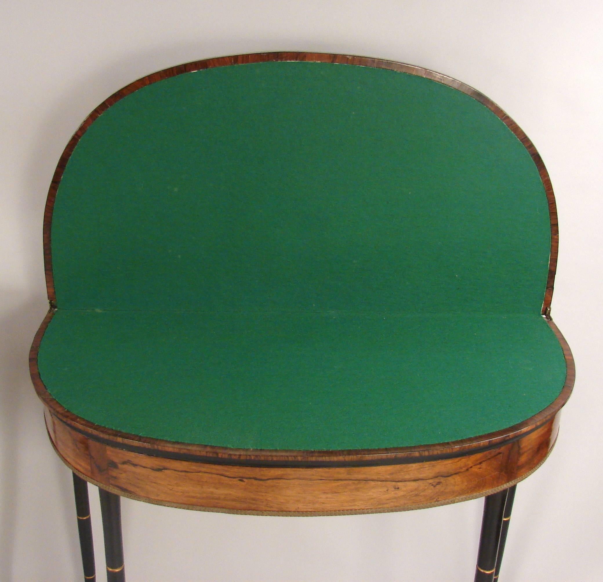 An elegant and stylish pair of English Regency period rosewood flip-top games tables, the interiors lined in green felt, each with ebonized faux bamboo legs and applied brass decorations to the aprons, circa 1815. Restored.