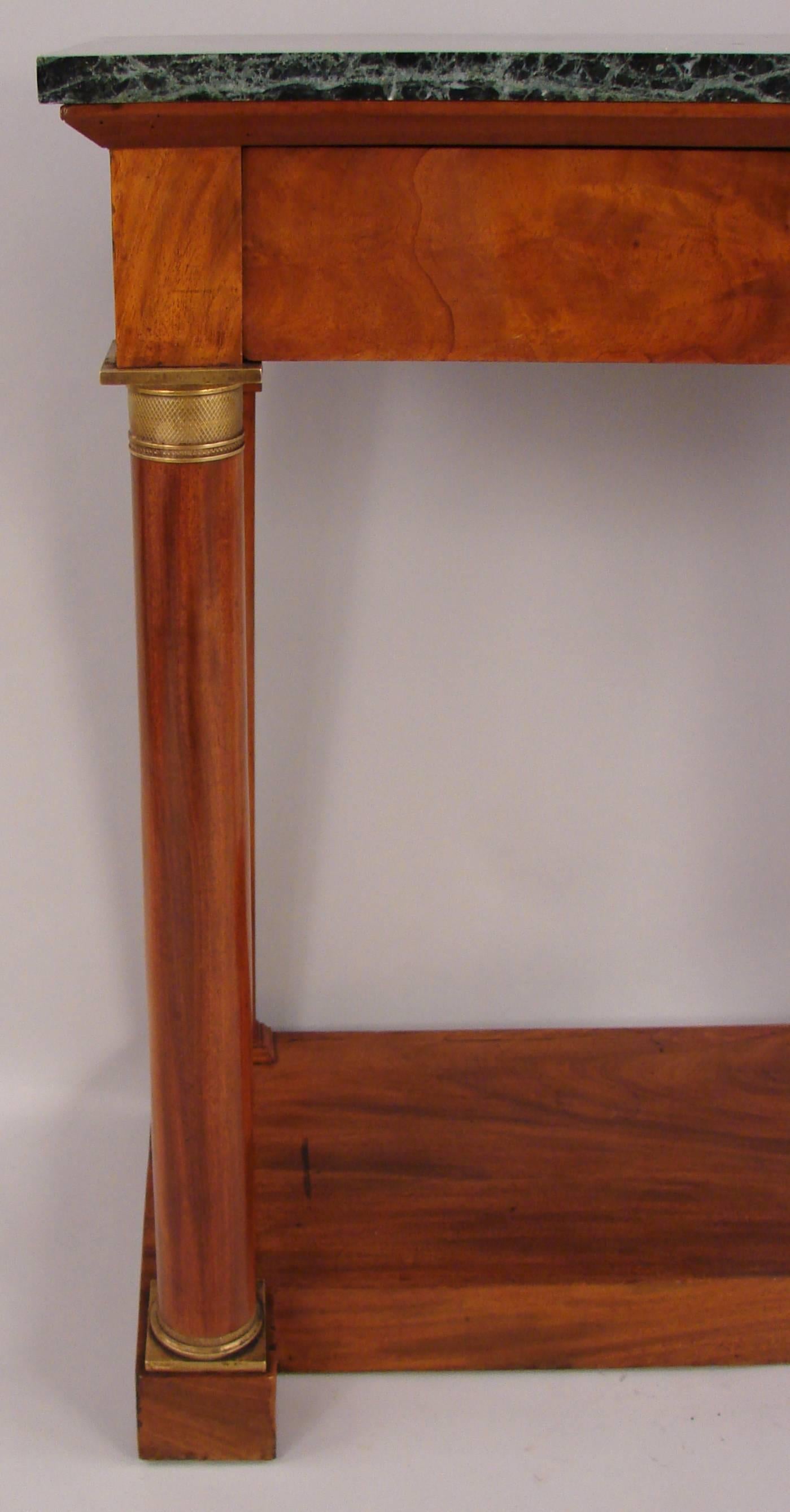 A Charles X period mahogany gilt metal mounted small console table, the replaced marble top above a single drawer flanked by columnar supports terminating in a plinth base, circa 1830.