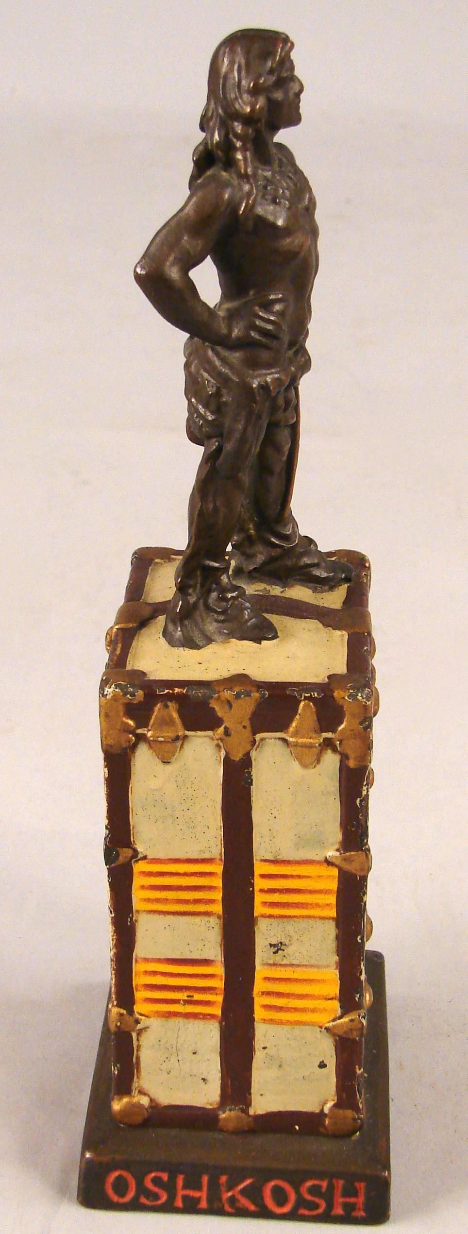 A rare American painted metal Oshkosh countertop advertising piece depicting a painted trunk surmounted with a figure of Chief Oshkosh. The Oshkosh luggage company ceased to exist in the middle of the 20th century. This piece advertised a line of