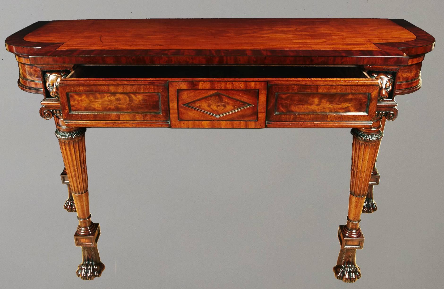 A fine Regency mahogany and ebony inlaid serving table, the D-shaped cross-banded top of breakfront form over a frieze fitted with a paneled drawer and centered by a diamond shaped lozenge, raised on finely carved columnar fluted supports headed