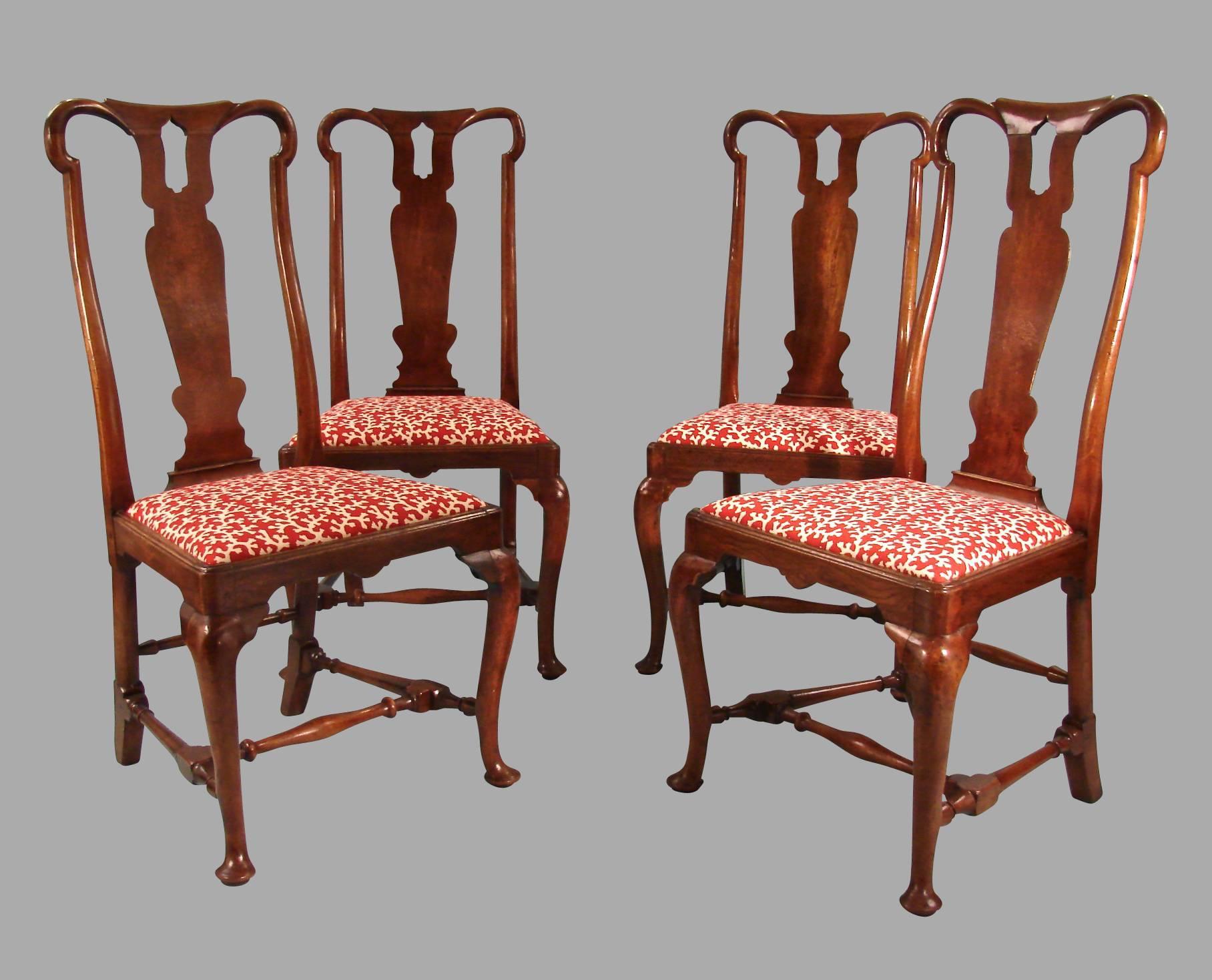 A rare set of four Queen Anne walnut chairs with unusual vasiform splats supported on cabriole legs joined by turned stretchers, circa 1720.