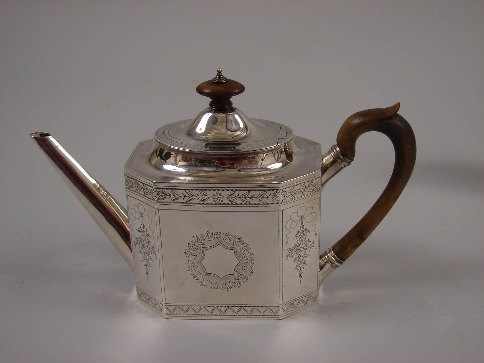 An English George III sterling silver teapot with paneled engraved sides decorated with ribbons and flowers made and hallmarked by Thomas Harper, London 1797, together with an unmarked sterling creamer probably by the same maker. Total silver weight
