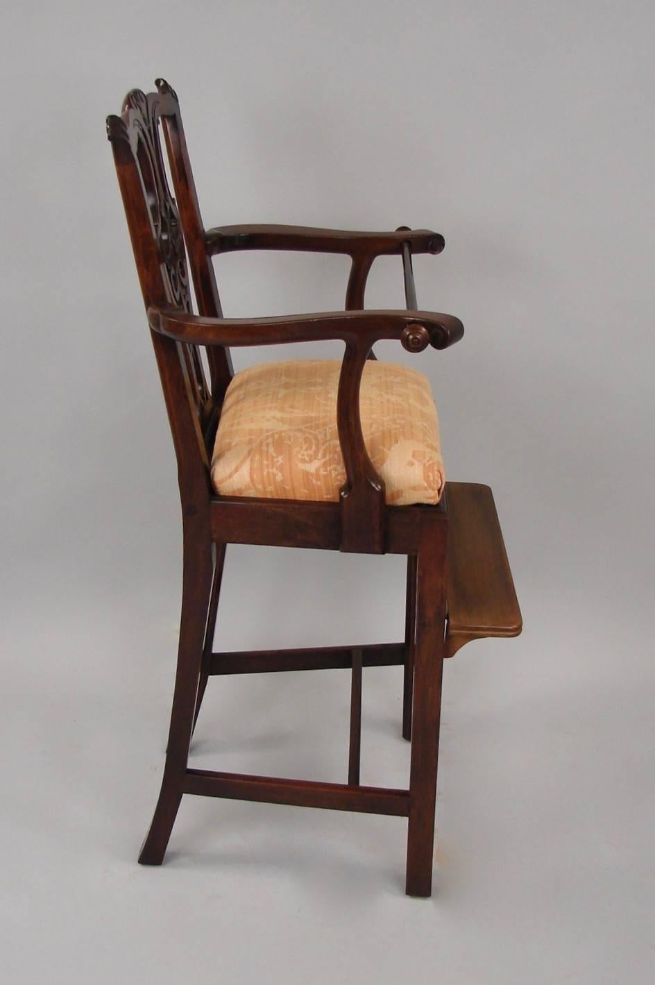 A George III style carved mahogany high chair with later adjustable footrest and retaining rod, circa 1850, repairs.