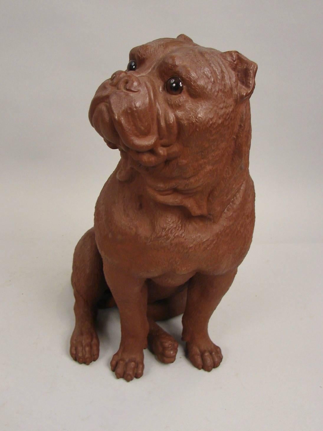 A well-modeled Austrian terracotta sculpture of a seated bulldog with glass eyes in an alert position, the lifelike animal gazing in your direction.