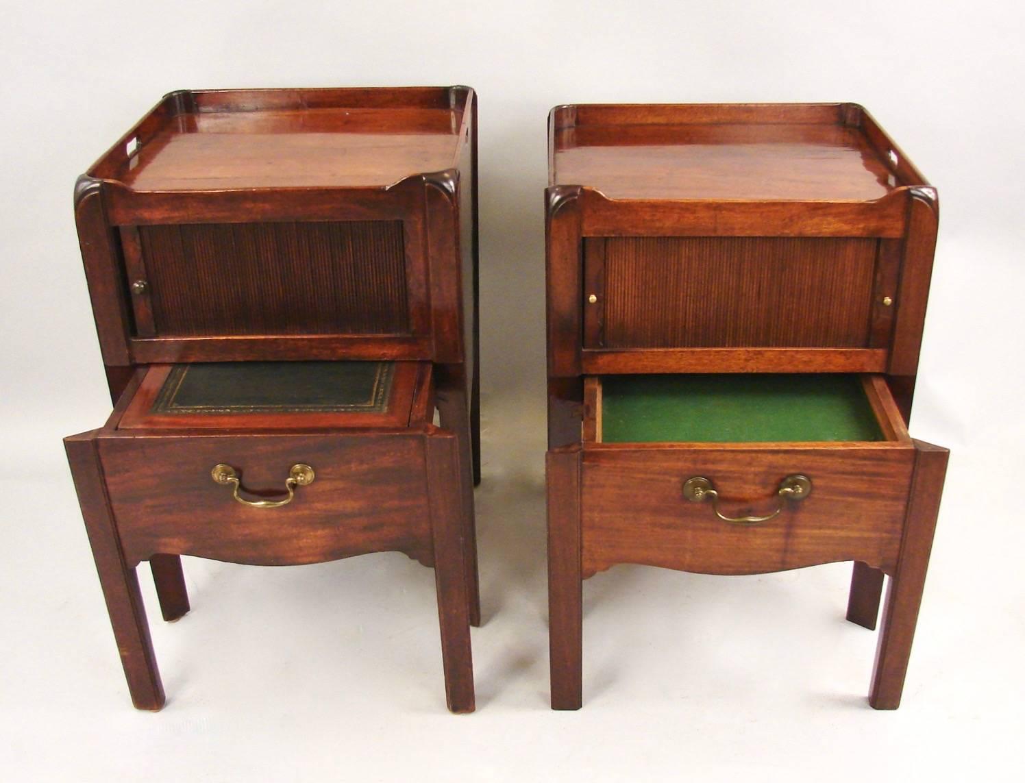 A matched pair of Georgian mahogany tray top bedside commodes with cut-out carrying handles, each with a sliding tambour above a modified single drawer with brass bale and a shaped apron supported on square legs, circa 1800-1820. Variations in