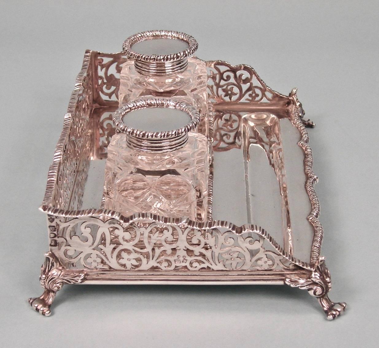 An English sterling standish with 2 inkwells and an elaborate filigree surround supported on paw feet, made and signed by Edward Barnard and Sons, Ltd. hallmarked for London, 1899.