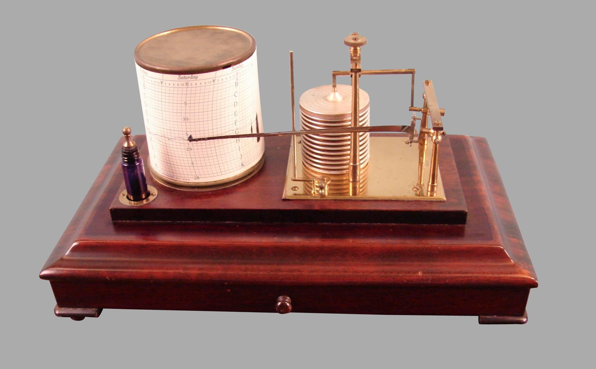 An English barograph made and signed by Short and Mason, the mahogany case with beveled glass top and sides and a shallow central drawer, the instrument consisting of a gilded brass with a silvered diaphragm aneroid barometer connected to a