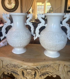 Pair of found Asian-Neoclassical style embossed brass dragon urns