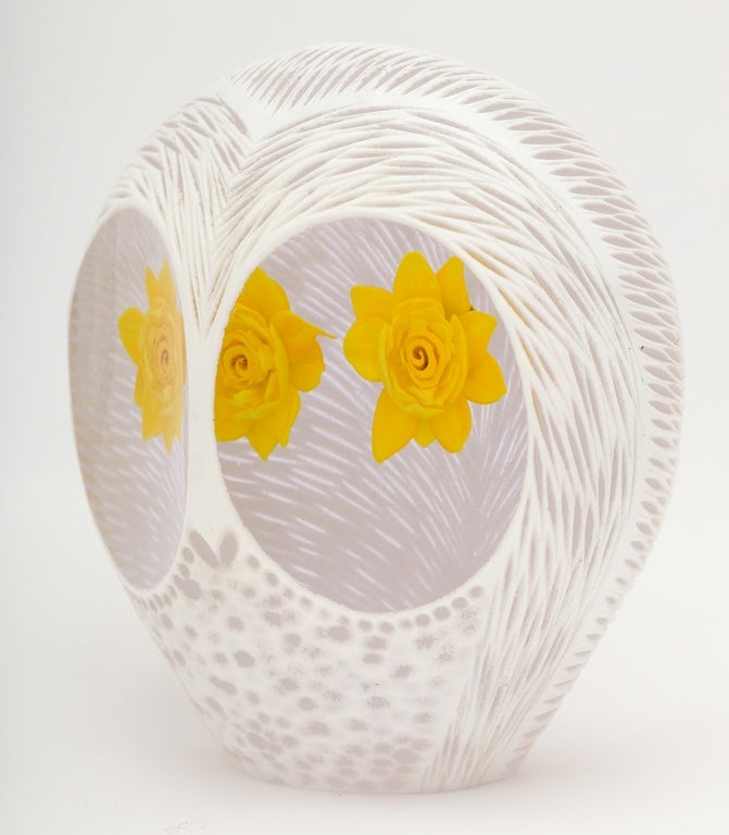 A Melissa Ayotte owl sculpture with two yellow roses within a white overlay to clear glass owl shape, the white glass carved to resemble feathers, signed M Ayotte, 2015.