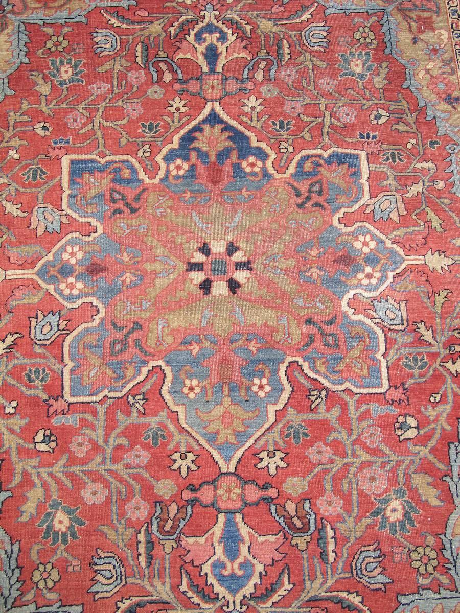 This small format carpet from the Heriz region of Northwest Persia draws an eight-pointed star medallion in medium blue against a madder red ground. A Fine weave allows for greater detailing rarely seen in larger Serapi carpets. Using the Persian