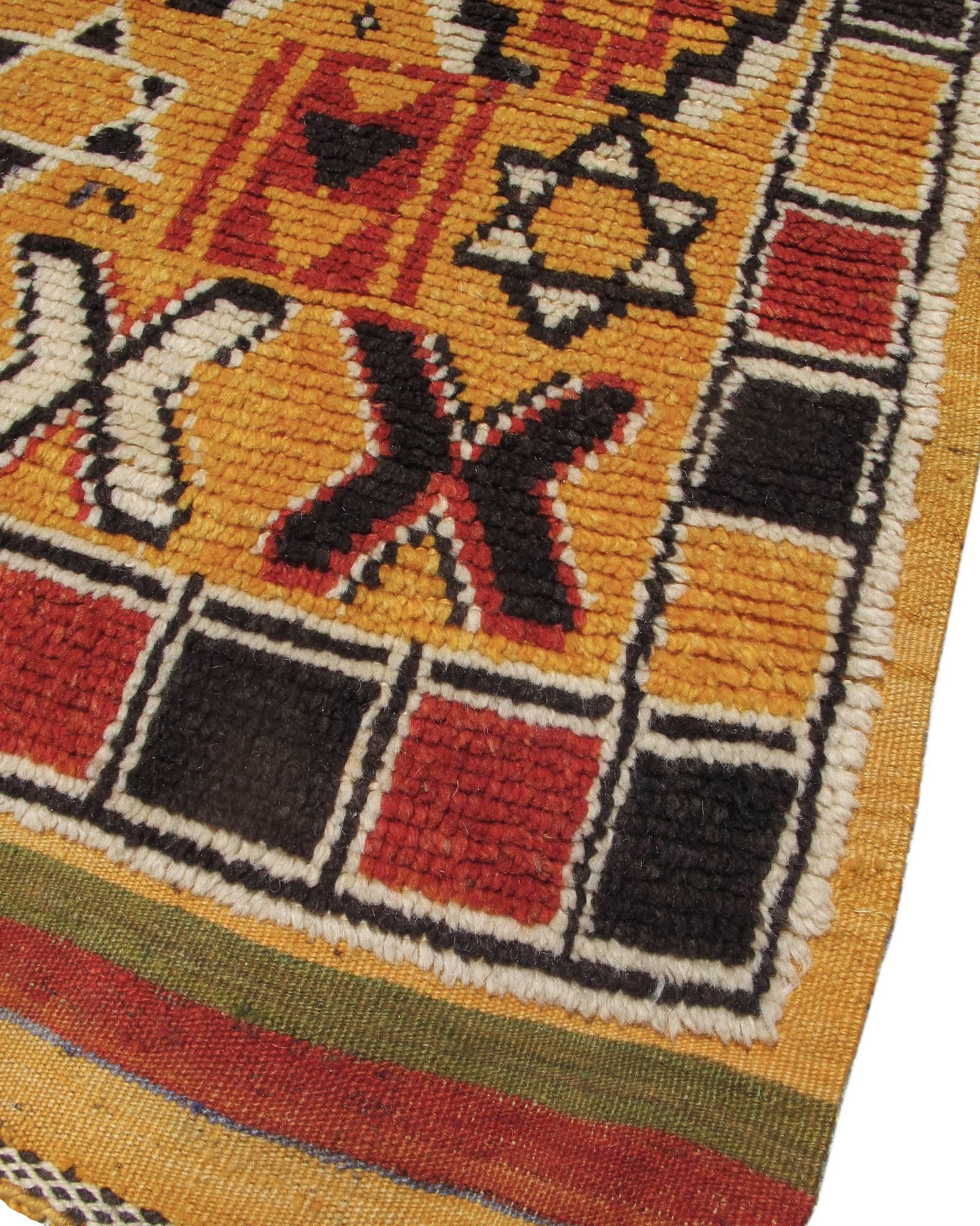 This pleasantly geometric Moroccan rug melds a field design of reciprocal stepped diamonds with a simple border of alternating black and red boxes. Of particular interest are two rows of six-pointed stars, perhaps reflective of the historically