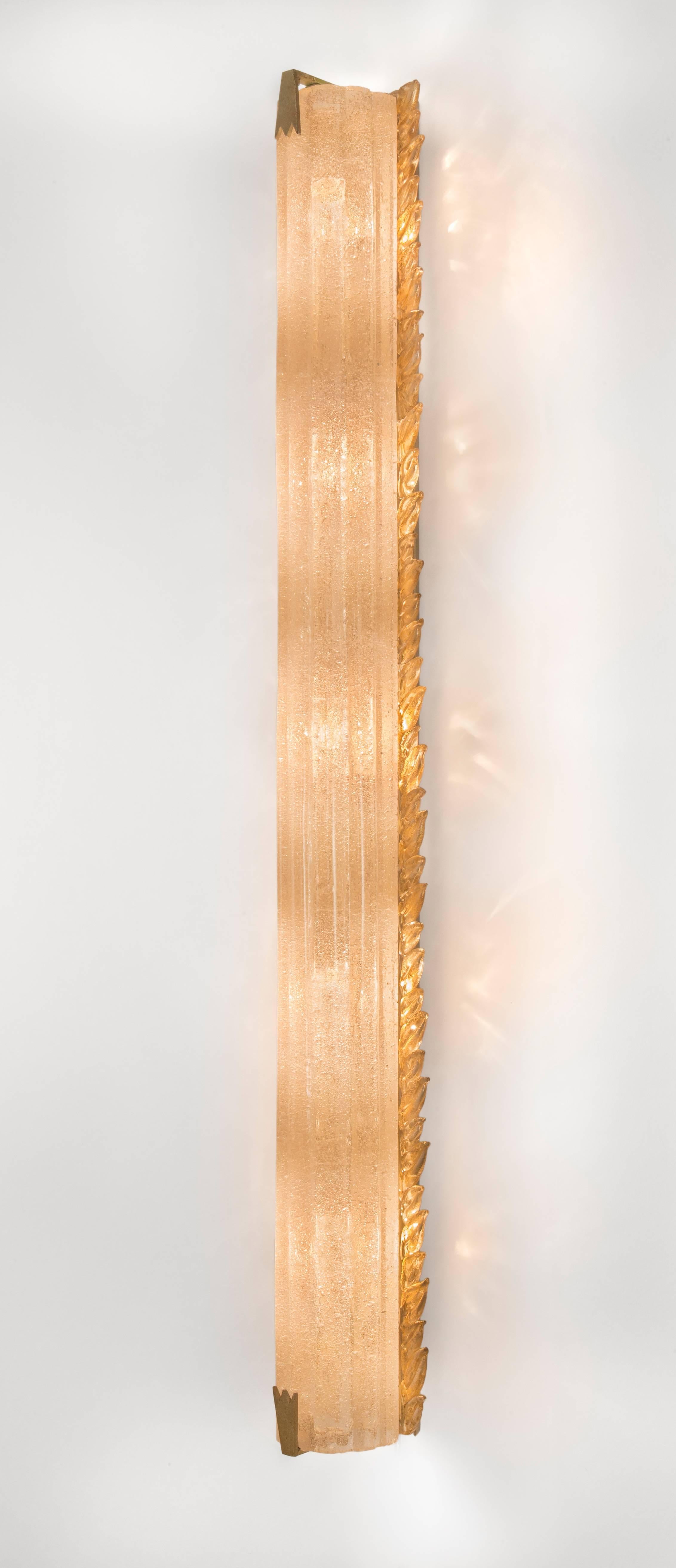 Each illuminated fluted column flanked by gold-flecked glass leaf tip molding. Can be hung both vertically or horizontally. Six sconces currently available. 