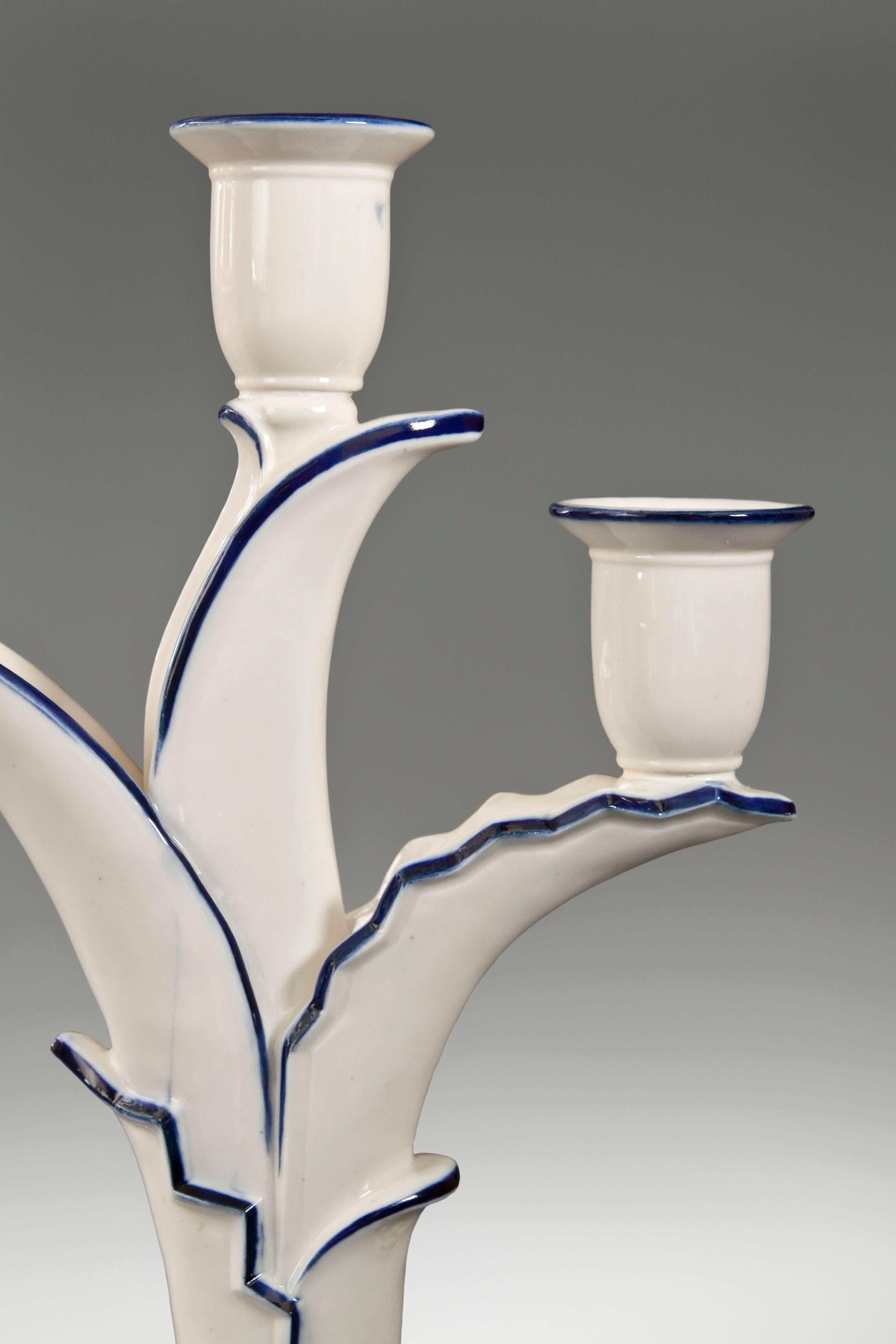 Schwarzburg Werkstätten, Pair of Cobalt & Ivory Glazed Porcelain Candelabra
Each in the form of a plant with unfurling leaves, issuing three candle holders, on a molded oval base with two stylized bracket feet.  Minor restorations, overall excellent