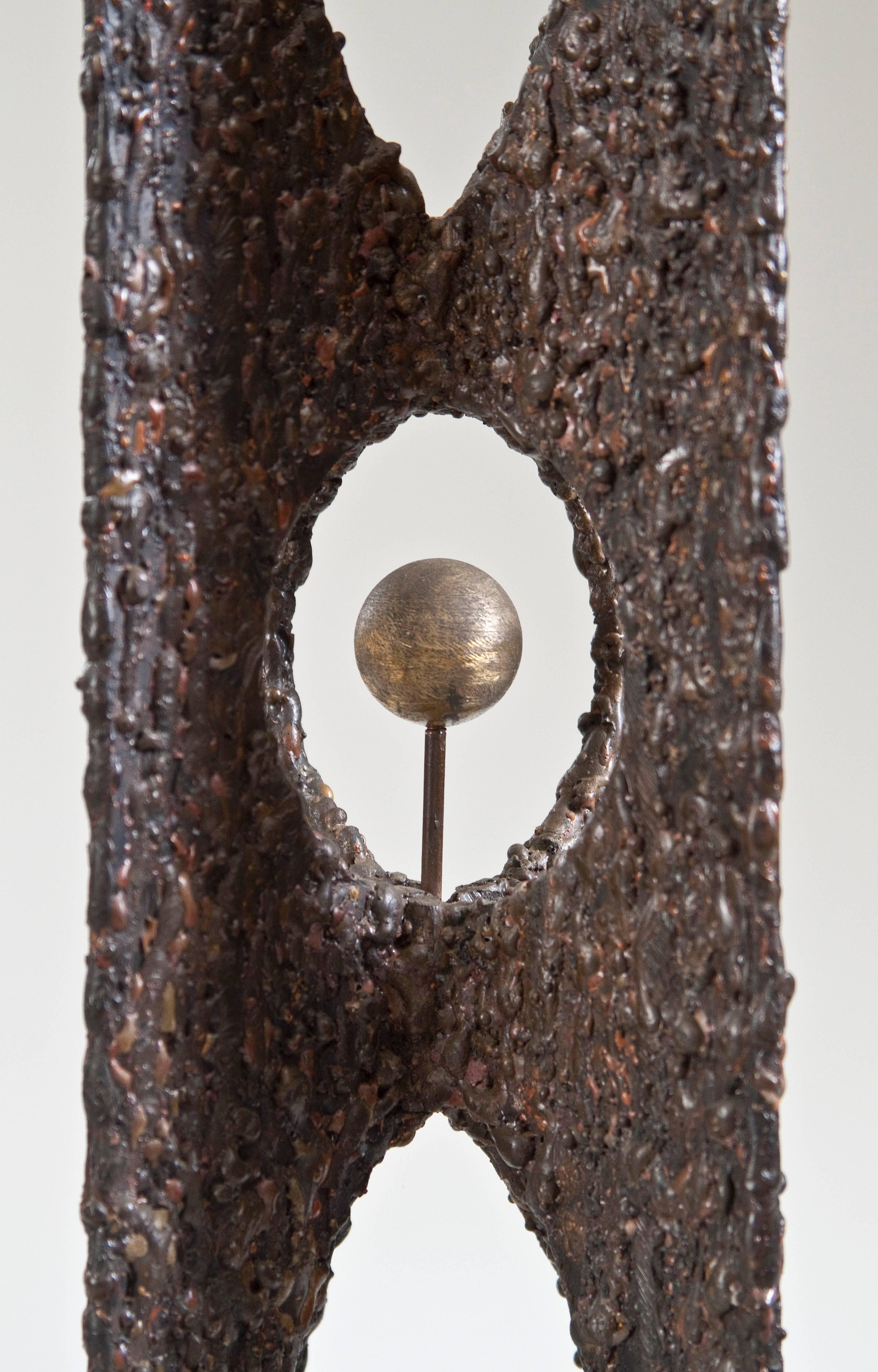 Raymond Granville Barger, American Abstract Bronze Sculpture
The four vertical elements joined to create an ellipital recess centering a polished brass sphere, of textured patinated bronze. Signed: RB 1973

Provenance: Private Collection, New
