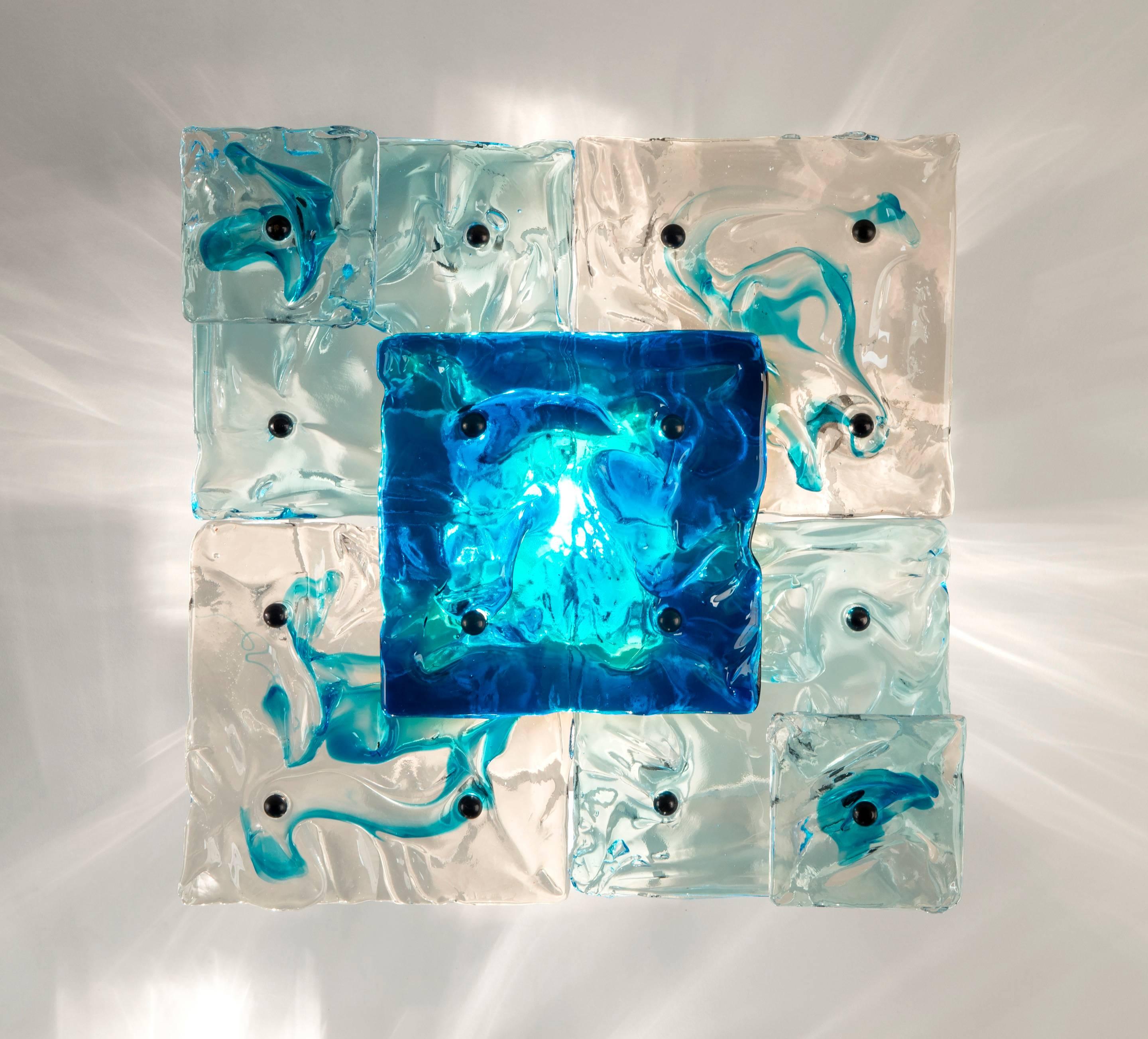 Each sconce composed of layered panels of uniquely-textured colorless and azure glass. Each stamped: Venini Murano.

These scones can also be interconnected and reconfigured to form a larger wall sculpture, as is illustrated by Franco Deboni,