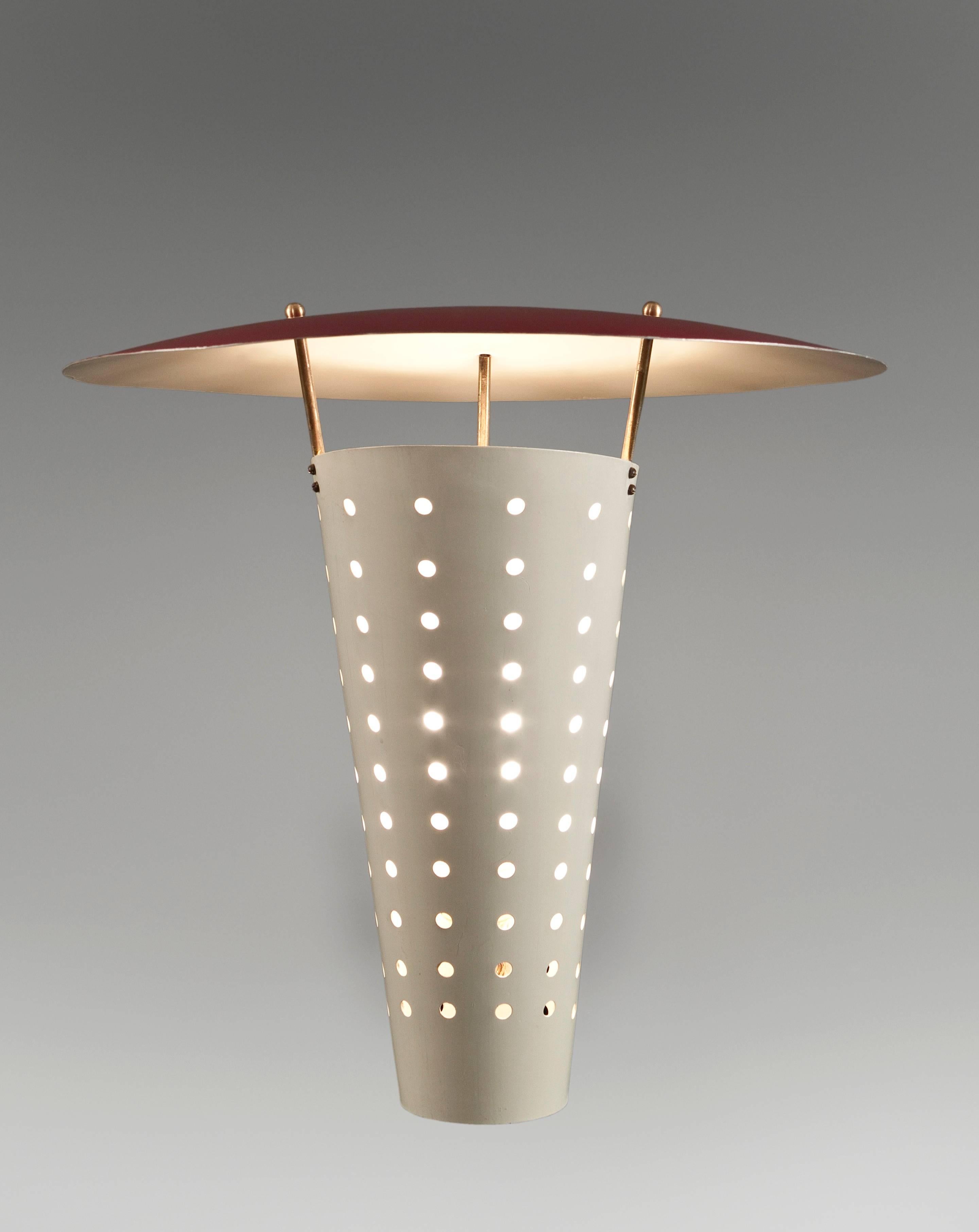 Large scale modernist sconces of a sophisticated yet deceptively simple design. The circular domed reflector raised on three uprights, above a perforated conical diffuser, supported by a rectangular backplate. Original paint in very good