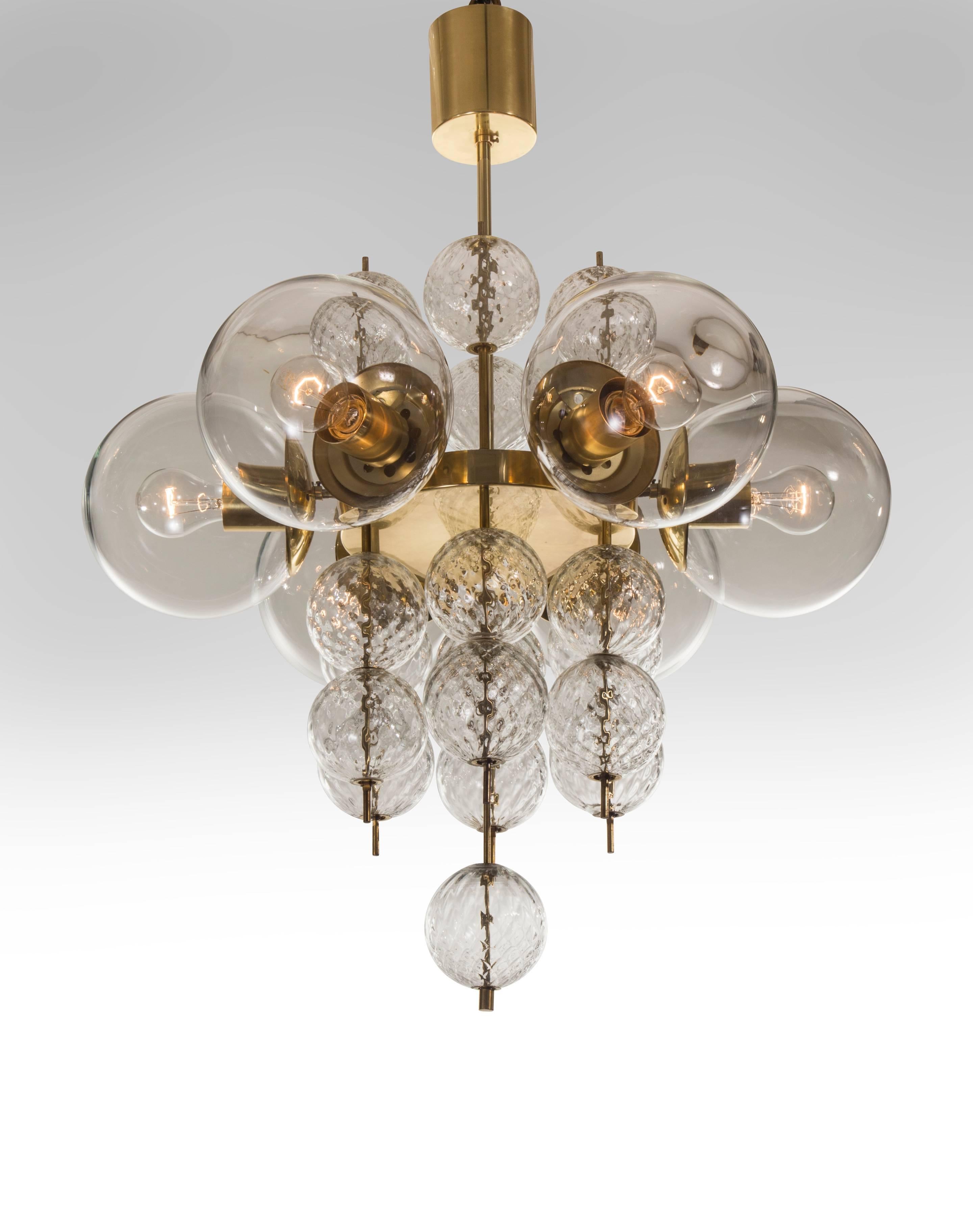 A spirited and chic design complete with all the original elements. Each cylindrical canopy, above a circular brass body issuing six lights enclosed by glass globes and adorned by quilted glass spheres floating on rods.

The height of the
