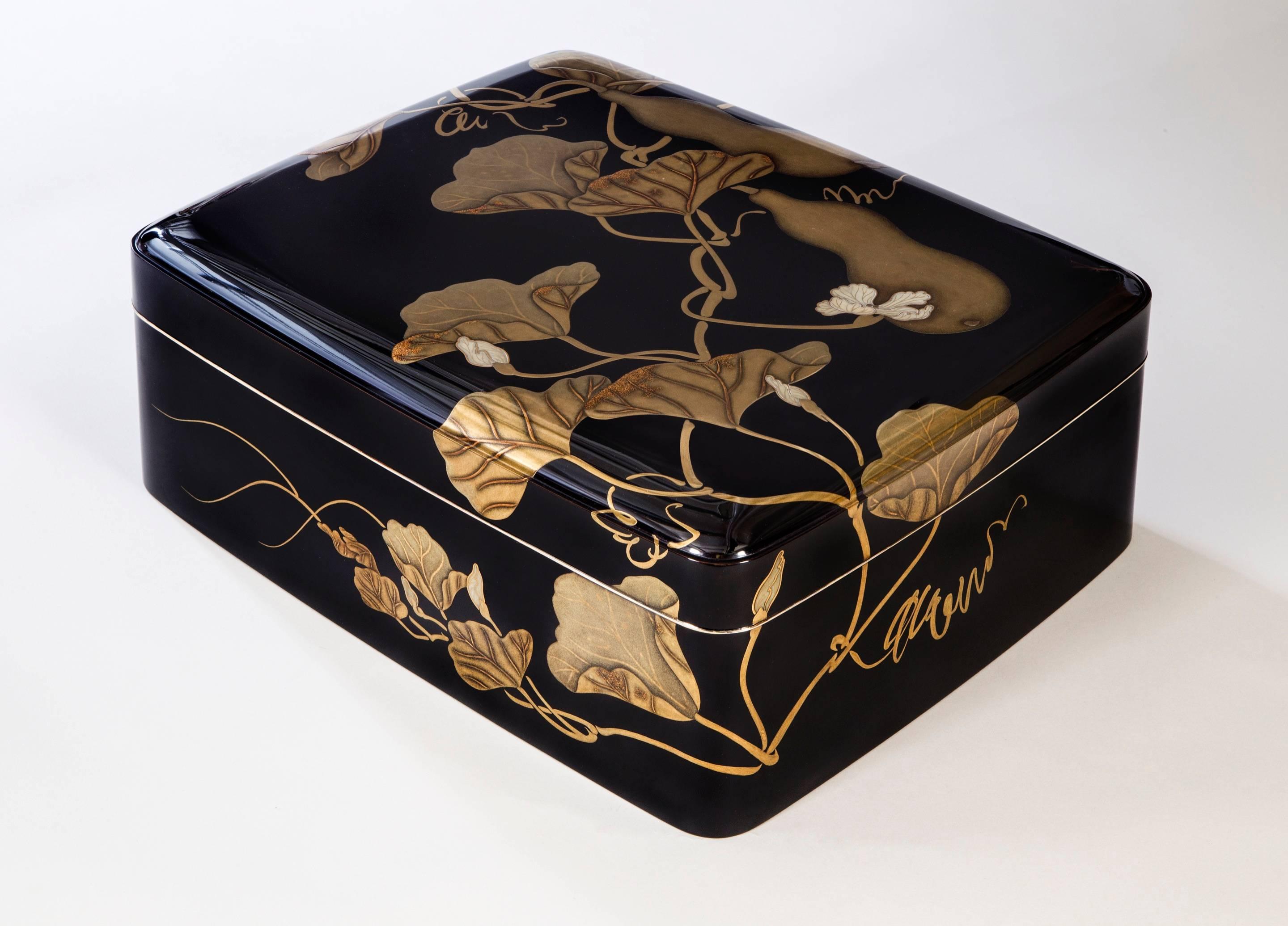 An exceptional box of the highest quality lacquer and of a striking modern design. The rectangular top with rounded corners depicting flowering and fruiting double gourd vines in hiramaki-e, takamaki-e, togidashi and nashiji, the interior depicting