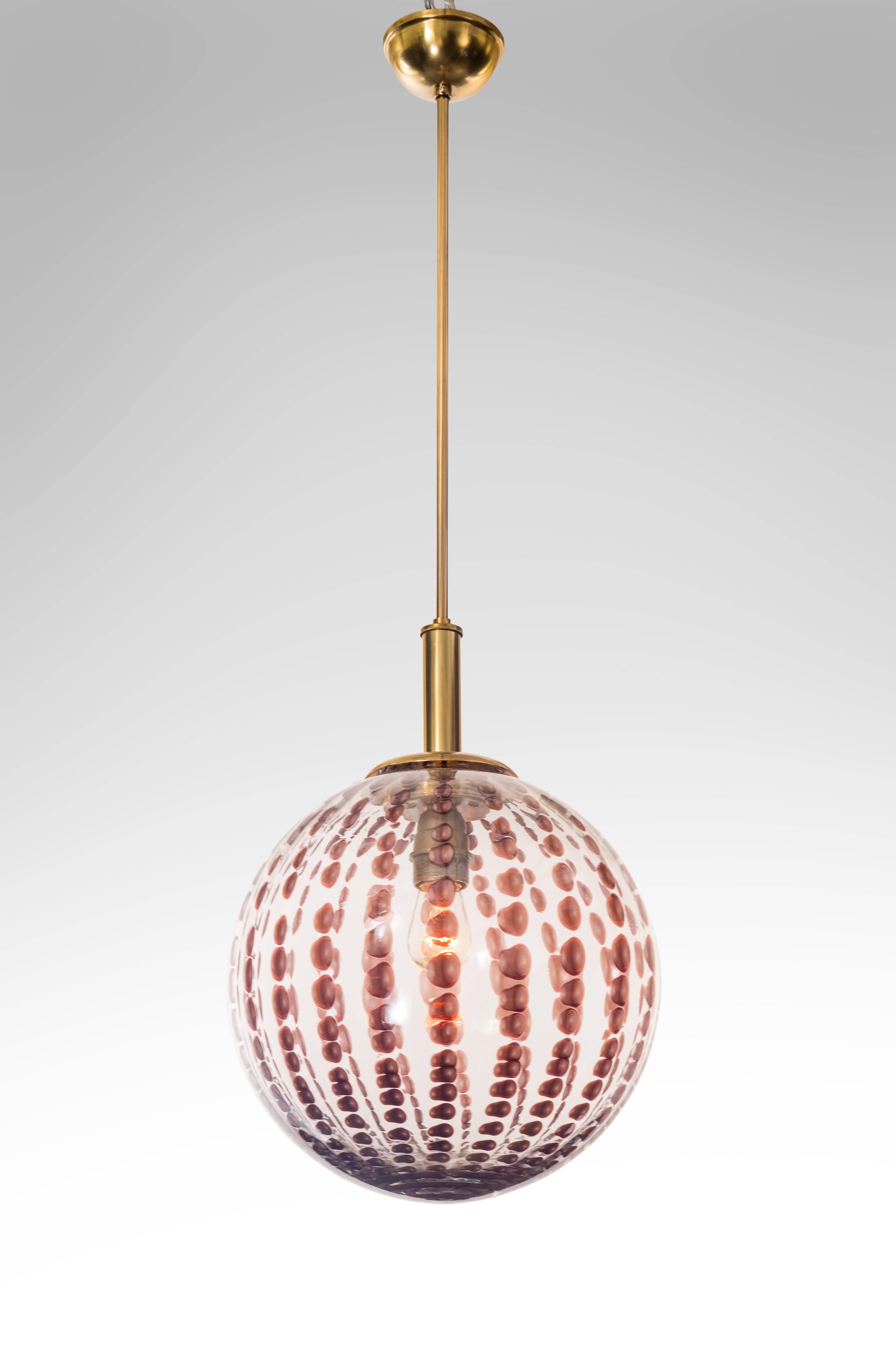 Very attractive colorless and amethyst glass globe. The brass fixture, supporting a spherical glass diffuser adorned in amethyst colored murrine glass inclusions, containing a single light holder.